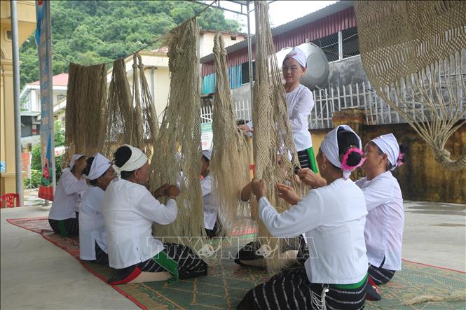 Các thành viên Tổ hợp tác sản xuất võng gai truyền thống tại xóm Long Thọ, xã Giai Xuân (Nghệ An) đan võng gai. Ảnh: Bích Huệ - TTXVN