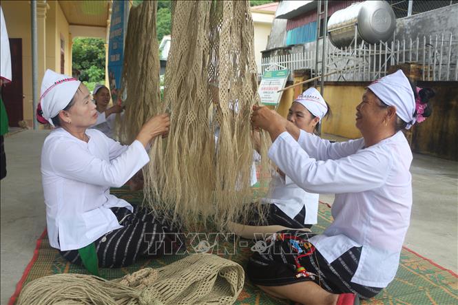 Phụ nữ dân tộc Thổ đan võng gai. Ảnh: Bích Huệ - TTXVN