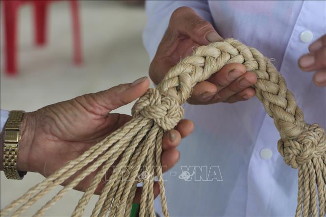 Công đoạn khó nhất trong việc đan võng là kết đai đầu võng. Ảnh: Bích Huệ - TTXVN