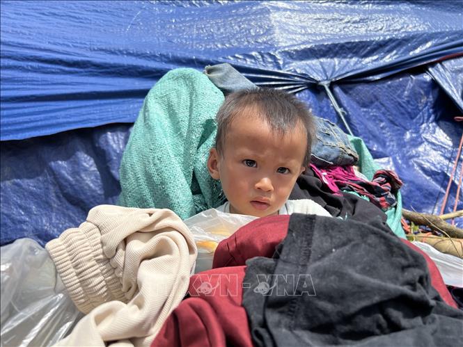 Em bé xóm Lũng Luông, xã Vũ Nông ở khu lều tạm. Ảnh: Chu Hiệu-TTXVN
