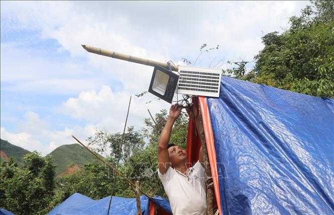 Người dân lắp đèn năng lượng để thắp sáng. Ảnh: Chu Hiệu-TTXVN