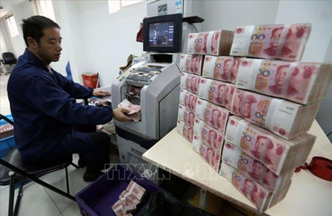 Nhân viên ngân hàng Công thương kiểm đếm đồng Nhân dân tệ tại thành phố Vô Tích, tỉnh Giang Tô, Trung Quốc. Ảnh: THX/TTXVN
