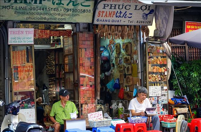 Hiện nay, chỉ còn vài cửa hàng giữ được nghề khắc con dấu gỗ thủ công. Ảnh: Khánh Hoà - TTXVN