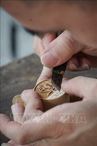 Công đoạn khó nhất của nghề chính là khâu chạm khắc, đây là khâu người thợ phải tập trung cao độ, cẩn thận và tỉ mỉ. Ảnh: Khánh Hoà - TTXVN