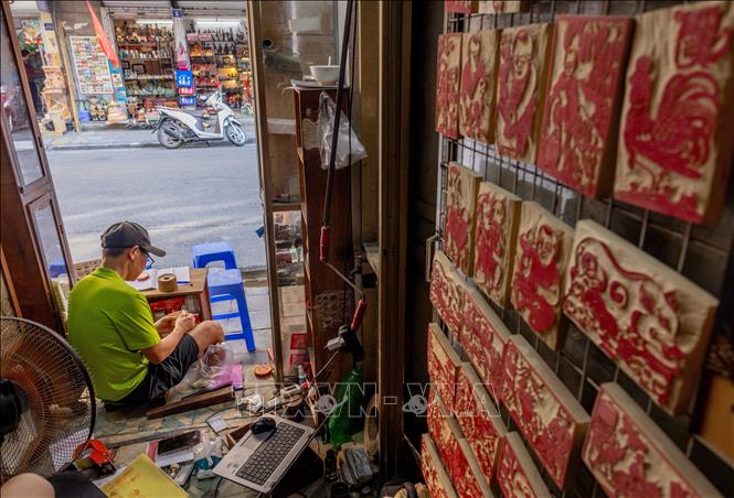 Một cửa hàng khắc dấu trên phố Hàng Quạt, được bao quanh bởi con dấu, bản khắc gỗ. Ảnh: Hoàng Hiếu - TTXVN