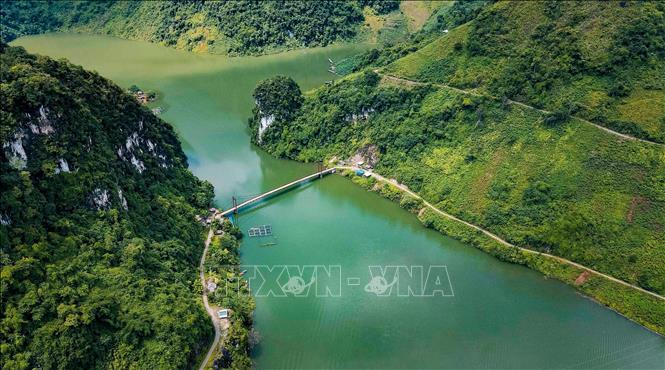 Nhìn từ trên cao, cầu treo Pa Phông hiện lên trên nền nước xanh biếc, giữa hai bên là núi non hùng vĩ. Ảnh: Xuân Tư - TTXVN