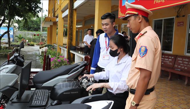 Cán bộ Đội Cảnh sát giao thông - trật tự (Công an huyện Phụng Hiệp) thực hiện tuyên truyền ATGT trong buổi sinh hoạt đầu tuần tại Trường THPT Hòa An. Ảnh: Hồng Thái - TTXVN