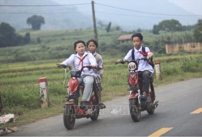 Học sinh nhỏ tuổi đèo nhau trên xe điện tham gia giao thông trên đường tỉnh 12B thuộc địa phận huyện Kim Bôi tiềm ẩn nhiều rủi ro về an toàn giao thông. Ảnh: Hải Đat-TTXVN
