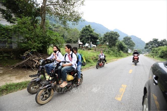 Rất nhiều học sinh sử dụng xe điện mà không thực hiện quy định đội mũ bảo hiểm. Ảnh: Hải Đat-TTXVN