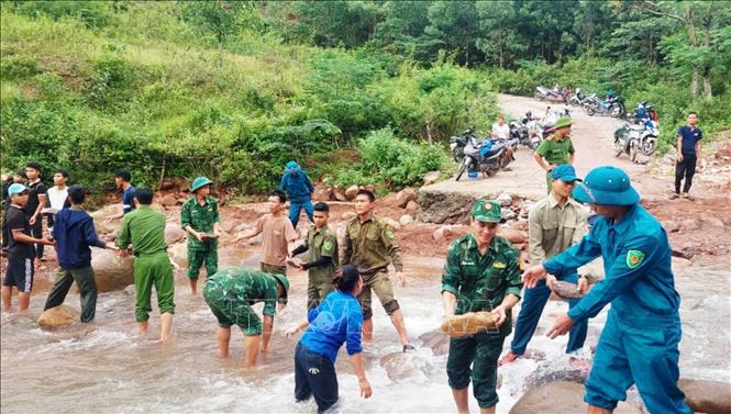Cán bộ, chiến sỹ Đồn Biên phòng Ra Mai (Bộ đội Biên phòng Quảng Bình) cùng đoàn viên Thanh niên, Công an và nhân dân xã Trọng Hóa, huyện Minh Hóa khắc phục, sửa chữa đường giao thông sau bão số 4. Ảnh: TTXVN phát