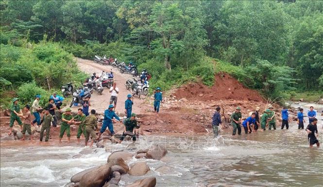 Các lực lượng san lấp, bồi đắp các đoạn bị hư hỏng, xói lở sau bão số 4. Ảnh: TTXVN phát
