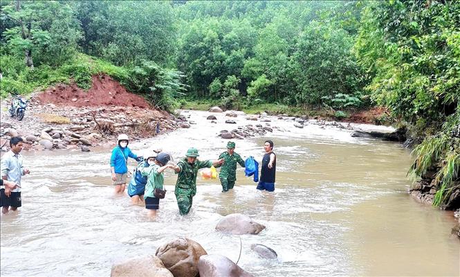 Bộ đội Biên phòng trên tuyến biên giới Quảng Bình hỗ trợ, hướng dẫn người dân di chuyển an toàn qua các điểm giao thông bị hư hỏng sau bão số 4. Ảnh: TTXVN phát