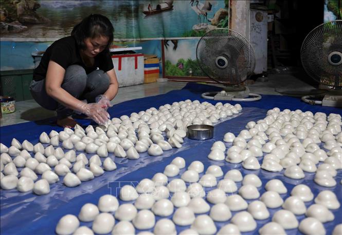 Bánh được xoa lớp mỡ để đóng gói. Ảnh: Trần Việt - TTXVN