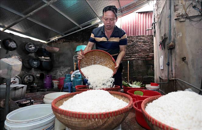 Gạo được ngâm và vo kỹ sau đó để ráo nước trước khi nấu xôi. Ảnh: Trần Việt - TTXVN