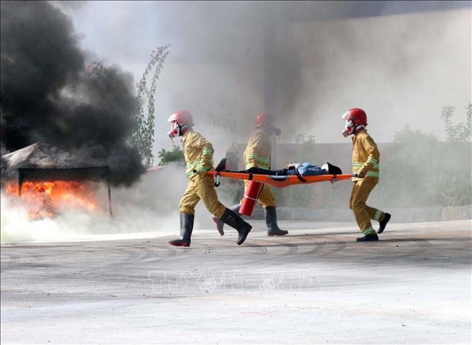  Lực lượng Cảnh sát phòng cháy, chữa cháy cứu hộ đưa nạn nhân trong vụ cháy đi cấp cứu. Ảnh: Công Thử - TTXVN