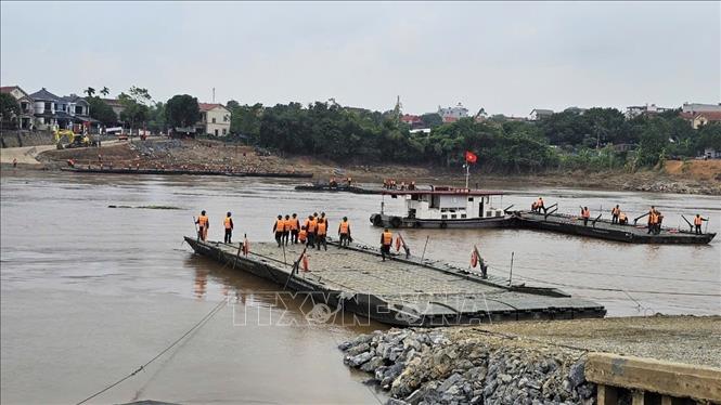 Đến 9h, công tác chuẩn bị đã hoàn tất, bắt đầu tiến hành lắp đặt cầu phao. Ảnh: Tạ Toàn-TTXVN