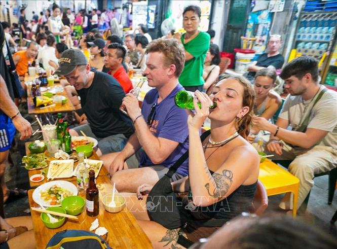 Du khách nước ngoài tập trung thưởng thức ẩm thực tại phố Tạ Hiện. Ảnh: Khánh Hòa - TTXVN