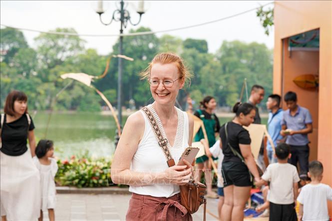 Du khách nước ngoài thích thú trải nghiệm không gian phố đi bộ hồ Hoàn Kiếm. Ảnh: Khánh Hòa - TTXVN