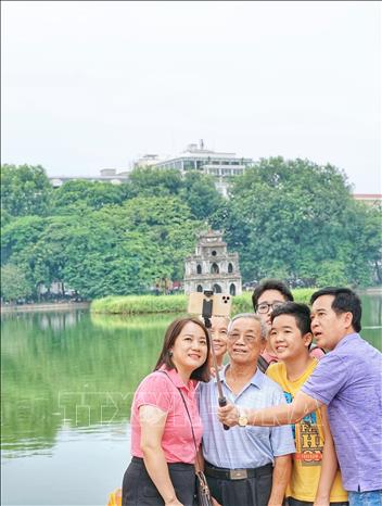 Rất nhiều người chọn không gian đi bộ hồ Hoàn Kiếm là điểm đến cho mình và gia đình dịp cuối tuần hay lễ tết. Ảnh: Khánh Hoà - TTXVN