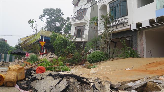 Đất ở dãy phố Tùng Tung ngày càng trồi lên cao khiến nhiều ngôi nhà bị xô nghiêng và có nguy cơ sập hoàn toàn. Ảnh: Hương Thu - TTXVN                            