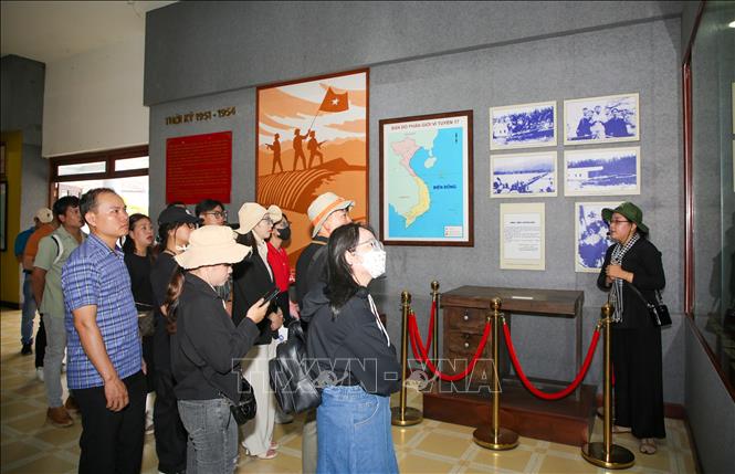 Du khách nghe hướng dẫn viên thuyết trình về quá trình làm việc của lãnh đạo Trung ương Cục miền Nam trong kháng chiến tại nhà trưng bày hiện vật. Ảnh: Giang Phương - TTXVN