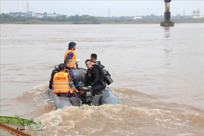 Lực lượng đặc công “người nhái” thực hiện nhiệm vụ tìm kiếm người mất tích trên sông Hồng. Ảnh: Tạ Toàn – TTXVN