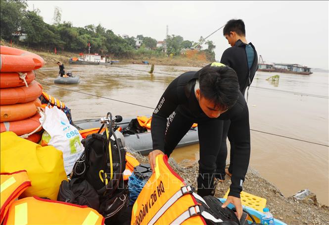 Người nhái lặn tìm kiếm khu vực cầu sập; đồng thời tìm kiếm theo địa chỉ thông tin do người dân cung cấp tại khu vực cầu Phong Châu bị sập. Ảnh: Tạ Toàn – TTXVN