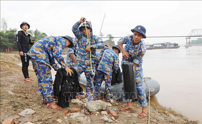 Đặc công “người nhái” cùng nhiều phương tiện chuyên dụng phục vụ công tác tìm kiếm người mất tích và trục vớt cầu Phong Châu bị sập vào sáng ngày 9/9. Ảnh: Tạ Toàn – TTXVN