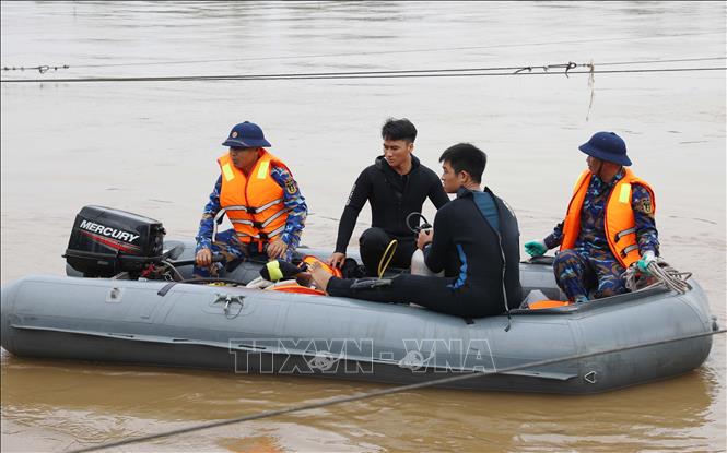 Người nhái lặn tìm kiếm khu vực cầu sập; đồng thời tìm kiếm theo địa chỉ thông tin do người dân cung cấp tại khu vực cầu Phong Châu bị sập. Ảnh: Tạ Toàn – TTXVN