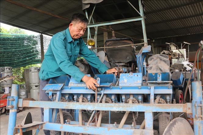 Ông Võ Văn Út đang kiểm tra máy gieo hạt ngô. Ảnh: Thanh Bình-TTXVN