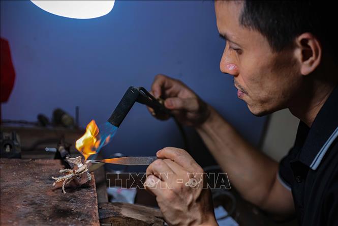 Nghệ nhân Quách Phan Tuấn Anh (một trong 2 nghệ nhân còn lại của làng) đang chế tác sản phẩm. Ảnh: Hoàng Hiếu - TTXVN