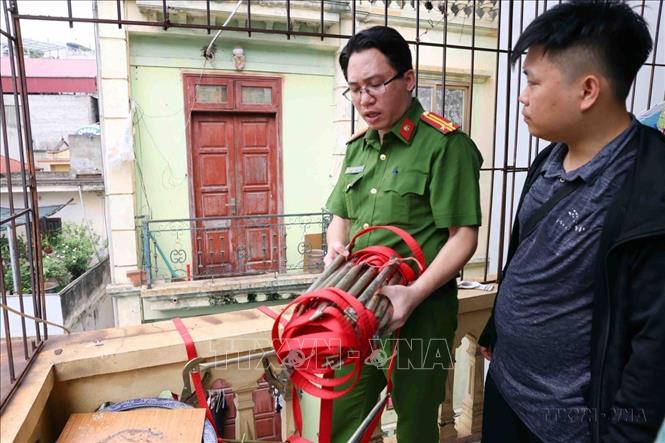 Lực lượng chức năng phường Trung Hoà, quận Cầu Giấy (Hà Nội) hướng dẫn, tuyên truyền cách sử dụng thang dây thoát nạn trong trường hợp xảy ra sự cố cháy nổ tại cơ sở kinh doanh nhà trọ trên đường Nguyễn Ngọc Vũ. Ảnh: Phạm Kiên - TTXVN