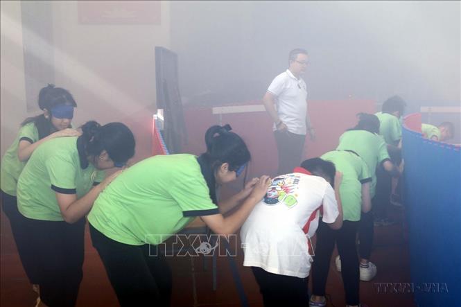 Cán bộ Viện Khoa học An toàn Việt Nam hướng dẫn học sinh Trường THCS Hoàng Văn Thụ (thành phố Lạng Sơn) cách thoát hiểm khi bị mắc kẹt trong đám cháy. Ảnh: Văn Đạt - TTXVN
