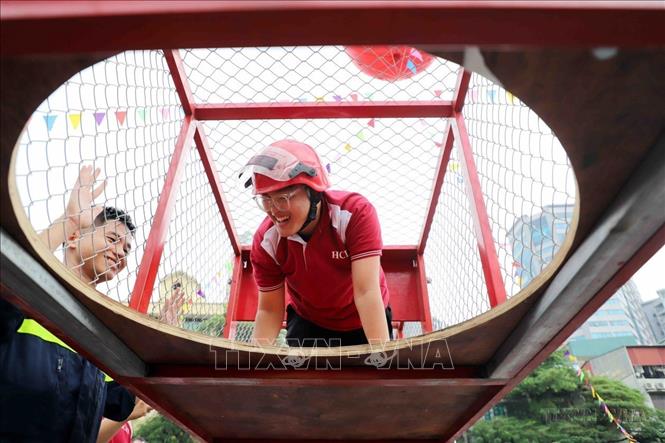 Người dân thủ đô thực hành thoát nạn trong không gian hạn chế tại hoạt động trải nghiệm kỹ năng chữa cháy và CNCH cho người dân và học sinh, sinh viên Hà Nội. Ảnh: Phạm Kiên - TTXVN