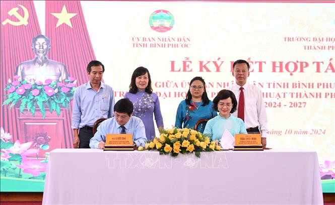 Phó Chủ tịch UBND tỉnh Bình Phước Trần Tuyết Minh và Phó Giáo sư, Tiến sỹ Lê Hiếu Giang, Quyền Hiệu trưởng Trường Đại học Sư phạm Kỹ thuật Thành phố Hồ Chí Minh ký kết hợp tác. Ảnh: Nhật Bình - TTXVN