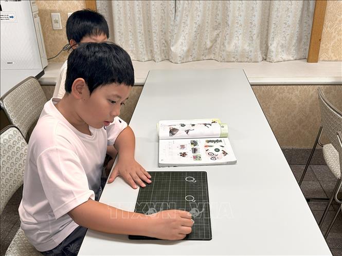 Học sinh nắn nót luyện viết chữ tiếng Việt. Ảnh: Nguyễn Tuyến - Pv TTXVN tại Nhật Bản 