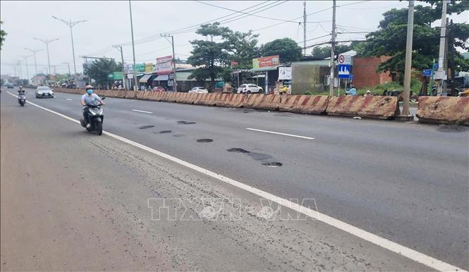 Đường ĐT.741 có thu phí nhưng nhiều ổ gà, ổ voi, sóng trâu gây mất an toàn cho phương tiện và người tham gia giao thông. Ảnh: TTXVN phát 