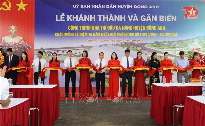 Các đại biểu thực hiện nghi thức cắt băng khánh thành, đưa vào sử dụng Nhà thi đấu đa năng huyện Đông Anh. Ảnh: Mạnh Khánh - TTXVN