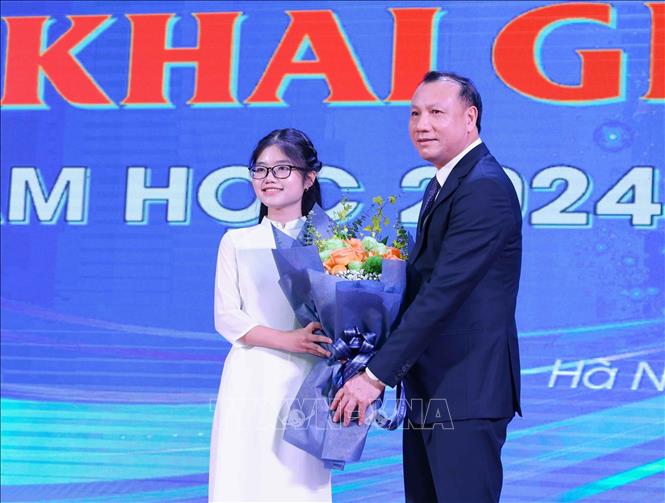 Đại diện sinh viên K74 tặng hoa, chúc mừng nhà trường nhân dịp khai giảng năm học mới. Ảnh: Thanh Tùng - TTXVN 