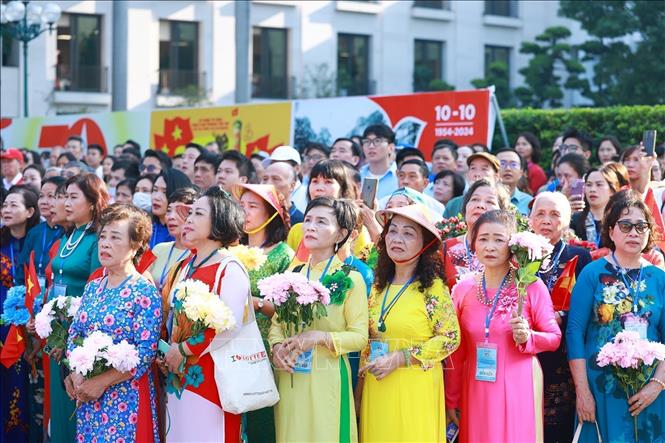 Quần chúng nhân dân chào cờ, hát quốc ca tái hiện buổi lễ chào cờ đầu tiên tại Hà Nội vào ngày 10/10/1954. Ảnh: Dương Giang-TTXVN