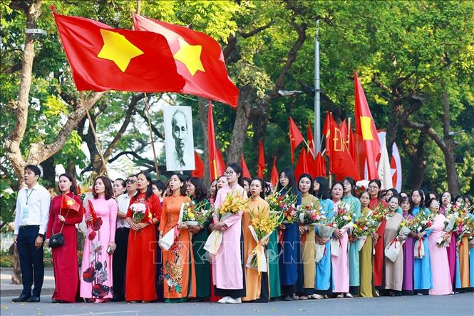 Quần chúng nhân dân Thủ đô chào cờ, hát quốc ca, tái hiện buổi lễ chào cờ đầu tiên tại Hà Nội vào ngày 10/10/1954. Ảnh: Dương Giang-TTXVN