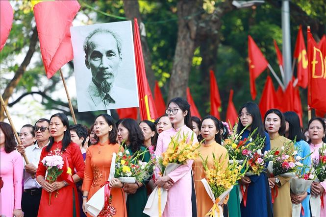 Quần chúng nhân dân Thủ đô chào cờ, hát quốc ca, tái hiện buổi lễ chào cờ đầu tiên tại Hà Nội vào ngày 10/10/1954. Ảnh: Dương Giang-TTXVN