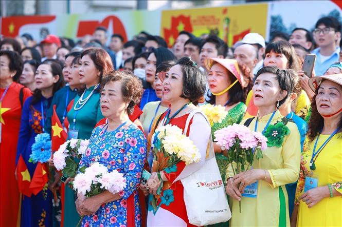 Quần chúng nhân dân Thủ đô chào cờ, hát quốc ca, tái hiện buổi lễ chào cờ đầu tiên tại Hà Nội vào ngày 10/10/1954. Ảnh: Dương Giang-TTXVN
