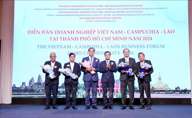 Ông Bùi Xuân Cường (thứ 3 từ phải sang), Phó Chủ tịch UBND Thành phố Hồ Chi Minh tặng hoa chúc mừng đại diện Ban tổ chức Diễn đàn. Ảnh: Xuân Khu-TTXVN