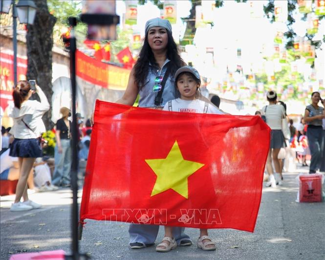 Người dân chụp ảnh với Quốc kỳ tại Không gian Bích họa Phùng Hưng. Ảnh: Tuấn Đức - TTXVN