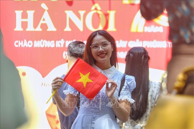 Các bạn trẻ phấn khích chụp ảnh cùng Quốc kỳ tại phố Phùng Hưng. Ảnh: Tuấn Đức - TTXVN