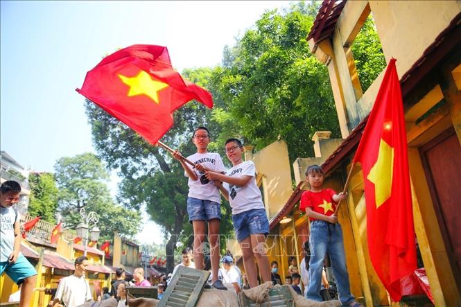 Các em nhỏ với Quốc kỳ trên phố bích họa Phùng Hưng. Ảnh: Tuấn Đức - TTXVN