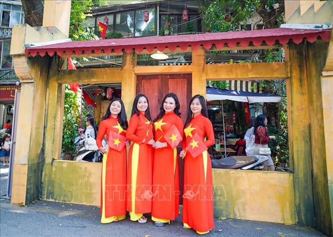 Các bạn trẻ chụp ảnh lưu niệm tại phố Phùng Hưng. Ảnh: Khánh Hòa - TTXVN