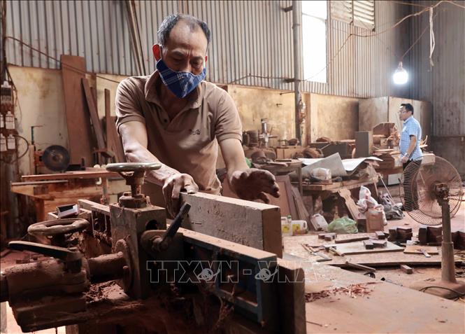 Cơ sở sản xuất đồ gỗ nhà ông Nguyễn Hữu Khuê ở thôn Nhị Khê thu hút hơn 10 lao động. Ảnh: Trần Việt - TTXVN