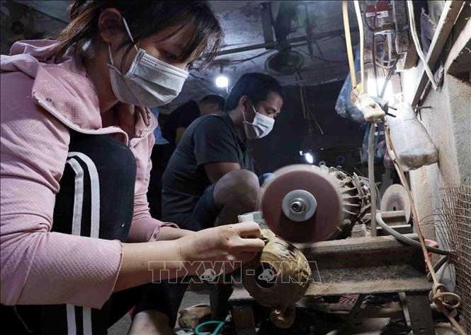 Mài bóng sản phẩm sau khi tiện. Ảnh: Trần Việt - TTXVN